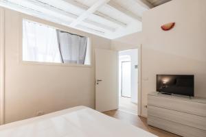 - une chambre avec un lit et une télévision sur une commode dans l'établissement Giardini del Castello Apartment, à Barletta