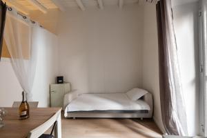 - une petite chambre blanche avec un lit et une fenêtre dans l'établissement Giardini del Castello Apartment, à Barletta