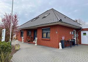 オッテルンドルフにあるHaus Seelotse in Otterndorf bei Cuxhavenの小さな赤レンガ造りの家(パティオ付)