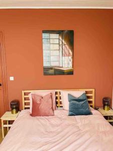 een slaapkamer met een bed met kussens en een raam bij Nieuw! Vakantiewoning Aventurien hartje Vlaamse Ardennen in Lierde