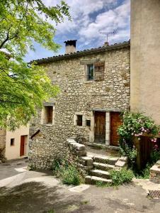 an old stone house with stairs in front of it at LA CALADE in Trigance