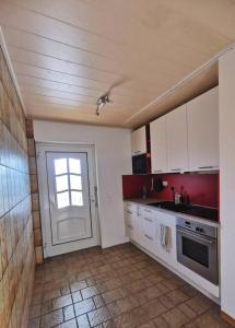 eine Küche mit einem Fenster und einer Tür mit einem Waschbecken in der Unterkunft Ferienwohnung in Diemelsee in Diemelsee