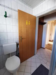 ein Badezimmer mit einem WC und einer Holztür in der Unterkunft Ferienwohnung in Diemelsee in Diemelsee