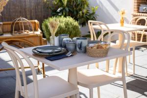 a white table with a plate of food on it at Casa Idalia Boutique Hotel in Comporta