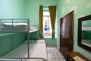 Pokój z łóżkiem piętrowym z 2 łóżkami piętrowymi i lustrem w obiekcie Naples Pizza Hostel w mieście Napoli
