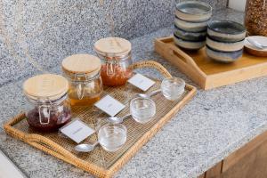 a tray with jars of honey and spoons on a counter at Casa Idalia Boutique Hotel in Comporta