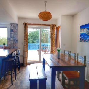 a dining room with a table and chairs and a window at Heart of Kernow Holidays in Bugle