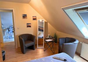 a attic room with two chairs and a mirror at Haus Seelotse in Otterndorf bei Cuxhaven in Otterndorf