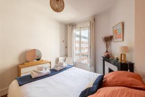 ein Schlafzimmer mit einem Bett mit Handtüchern darauf in der Unterkunft Villeneuve - Cosy et élégant appartement à Mairie de Clichy in Clichy