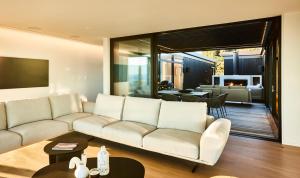 a living room with a white couch and a table at ONYX HOUSE - Wainui Beach in Gisborne