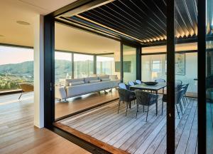 a living room and dining room with a table and chairs at ONYX HOUSE - Wainui Beach in Gisborne