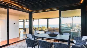 a dining room with a table and chairs at ONYX HOUSE - Wainui Beach in Gisborne