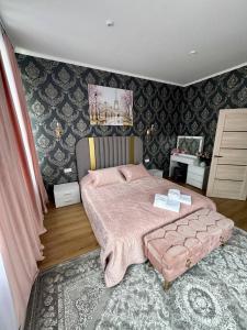 a bedroom with a pink bed with a pink blanket at Emerald Apartament in Chernivtsi
