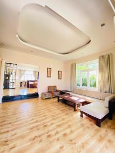 een grote woonkamer met houten vloeren en een wit plafond bij SEALINKS VILLA in Ấp Phú Tịnh (2)