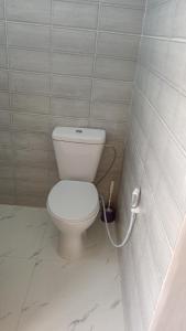ein Badezimmer mit einem weißen WC in einer gefliesten Wand in der Unterkunft الشوبك نجل in Nijil
