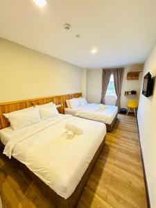 a hotel room with two beds and a window at Swing & Pillows - Apple Hotel Shah Alam in Shah Alam