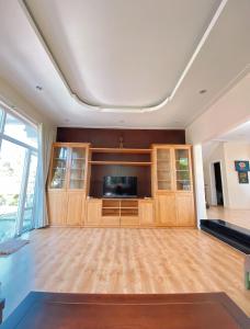 uma ampla sala de estar com uma televisão de ecrã plano e armários de madeira em SEALINKS VILLA em Ấp Phú Tịnh (2)