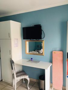 a desk with a computer and a chair in a room at Buxton lodge Guesthouse in Queenstown