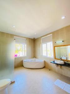 een grote badkamer met een groot bad en 2 wastafels bij SEALINKS VILLA in Ấp Phú Tịnh (2)