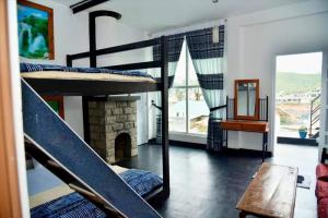a bedroom with a bunk bed and a fireplace at Shinycot in Nuwara Eliya