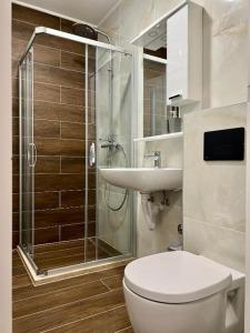 een badkamer met een douche, een toilet en een wastafel bij Apartment TT Jahorina in Jahorina