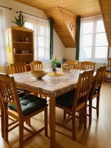 a dining room with a wooden table and chairs at Apartmány Srub Jenišov in Horní Planá