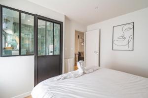- une chambre avec un lit blanc et une grande fenêtre dans l'établissement CASA CHAMALLOW, à Bailly-Romainvilliers