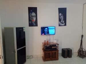 een kamer met een koelkast en foto's aan de muur bij Casa Cacheu low cost family house in Bissau