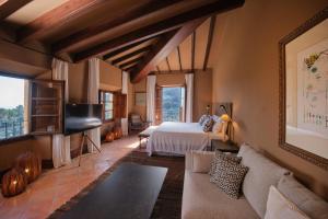 a bedroom with a bed and a couch in a room at Hotel Valldemossa - New Opening 2024 in Valldemossa