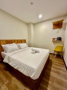 a bedroom with a bed and a yellow chair at Swing & Pillows - Apple Hotel Shah Alam in Shah Alam
