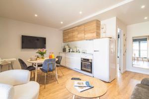 cocina y sala de estar con nevera y mesa en CASA CHAMALLOW, en Bailly-Romainvilliers