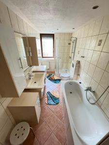 特拉森海德的住宿－Feriendomizil im Dünenwald，带浴缸、两个盥洗盆和卫生间的浴室
