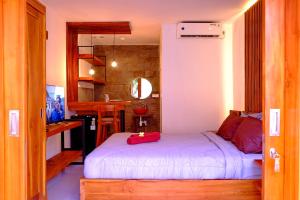a bedroom with a white bed and a kitchen at O.B oemah bone homestay in Sanur