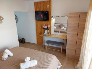 a bedroom with a bed and a desk with a mirror at Afandou Square Apartment in Afantou