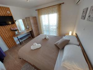 a bedroom with a bed with two towels on it at Afandou Square Apartment in Afantou +30 photos