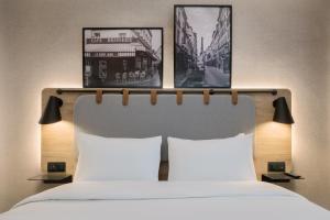 ein Schlafzimmer mit einem Bett mit zwei Bildern darüber in der Unterkunft Campanile Nîmes Centre Mas-Carbonnel in Nîmes