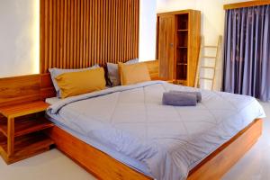 une chambre avec un grand lit avec une tête de lit en bois dans l'établissement O.B oemah bone homestay, à anur 15 autres photos
