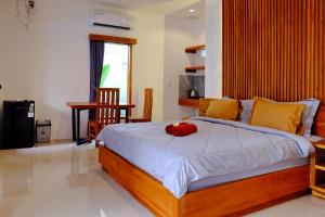 une chambre avec un lit avec un oreiller rouge dessus dans l'établissement O.B oemah bone homestay, à anur