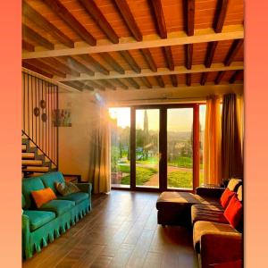 a living room with a couch and a large window at Agriturismo La Corte del Sole in Siena