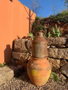 an old jug sitting next to a stone wall at Quinta dos Cedros l Turismo Rural in Covilhã