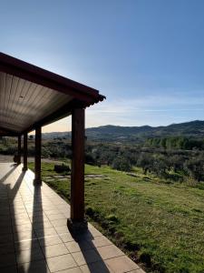 a porch with a roof with a view of a field at Quinta dos Cedros l Turismo Rural in Covilhã