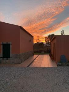 a sunset over a building with the sun setting at Quinta dos Cedros l Turismo Rural in Covilhã