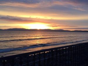 a sunset on the beach with the ocean at Delightful Beach Retreat- in Rossnowlagh +5 photos