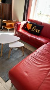 a living room with a red leather couch and a table at Aura centrum in Piešťany