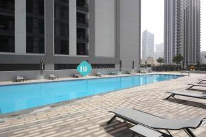 a swimming pool with chaise lounges in a city at Brand New Luxury 2 Bedroom Apartment in Abu Dhabi