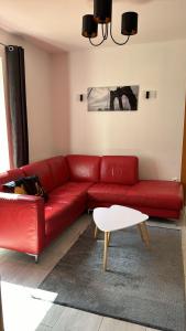 a red couch in a living room with a table at Aura centrum in Piešťany