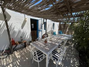 a patio with a table and chairs under a pergola at Kom Kyk Cottage in Merweville in Merweville