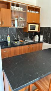 a kitchen with a black counter top and wooden cabinets at Aura centrum in Piešťany