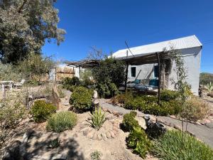 a house with a garden in front of it at Kom Kyk Cottage in Merweville in Merweville +9 photos