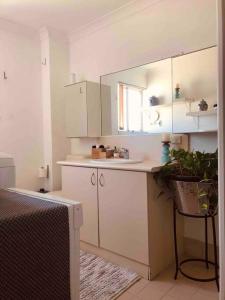 una cocina con armarios blancos y una maceta en Family Getaway en Perth